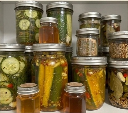 Jars of home-pickled cucumbers and preserves made at Bacon Acres