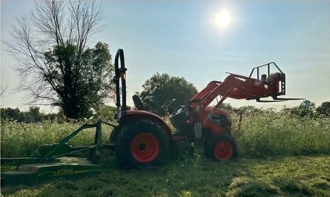 Kioti tractor working a hay field at sunrise on Bacon Acres